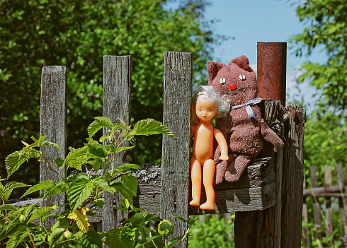 old retro toys hanging on wooden fence outdoors