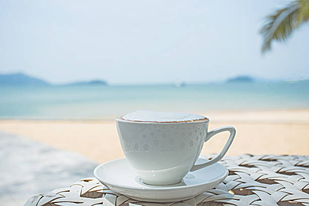 istock cup of coffee on white beach table 540574878
