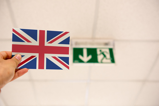 Sofia, Bulgaria. 17 June, 2016. Illustrative Editorial of a hand holding the UK flag next to an EXIT sign to illustrate that a week from the EU referendum, polls in the UK reveal a leading swing towards Brexit as campaigns enter final stage.