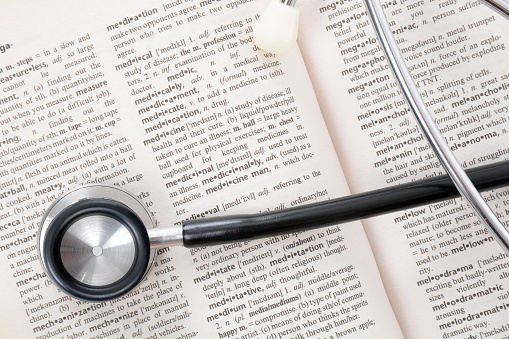 stethoscope laying on dictionary page open to the word medical