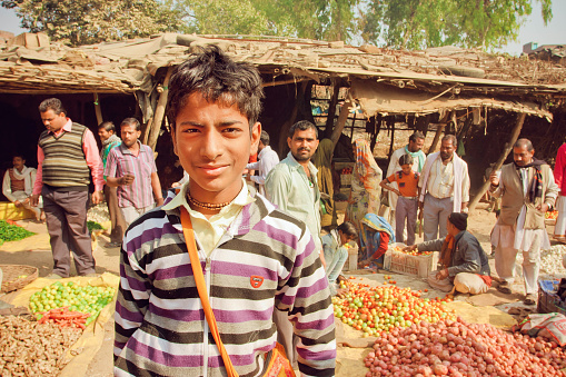 Madhya Pradesh, India - December 29, 2012: Unidentified teenager standing in crowd of customers of village vegetable market on December 29, 2012 in Chitrakoot. Population of Chitrakoot is 22,294 people