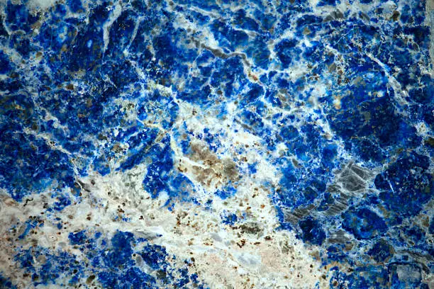 Natural texture background - polished surface of lapis lazuli (lazurite, azure stone) mineral gemstone  close up