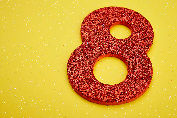 istock Number eight red color over a yellow background. Anniversary 540583006