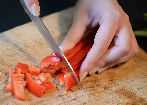 istock Female slicing pepper for salad. Close up chef cutting vegetabl 540583182