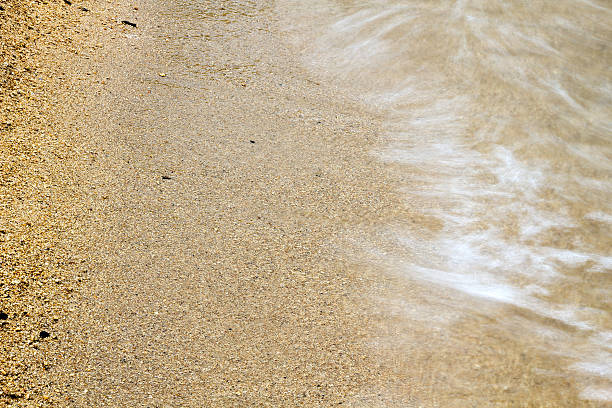 мягкие волны на песчаный пляж.-движения размытым - tide beach sand close up стоковые фото и изображения