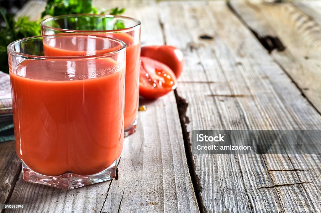 Tomato juice Still-life of fresh tomatoes and juice on a wooden table. Tomato Juice Stock Photo