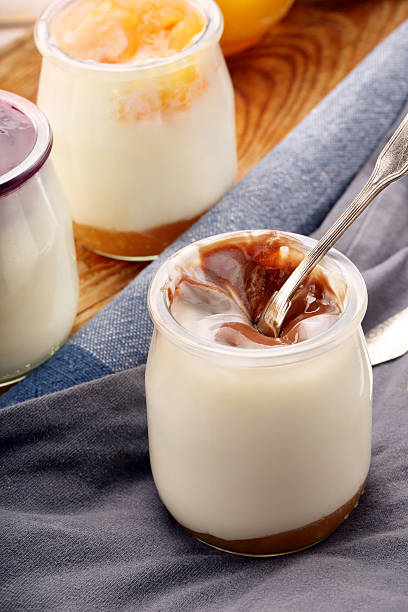 istock White yoghurt dessert in a jar on wooden background 540593396