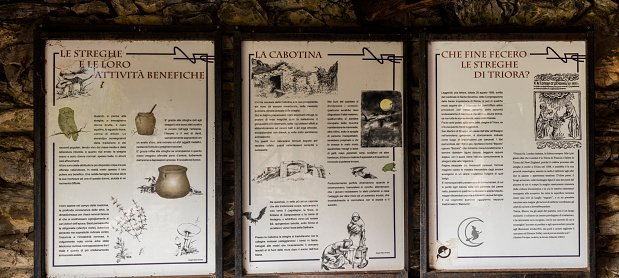 Triora, Italy - September 12, 2015: Information plaques telling the story of the witches in the village streets. Triora was the site of the last witch trials held in Italy, during the Renaissance.