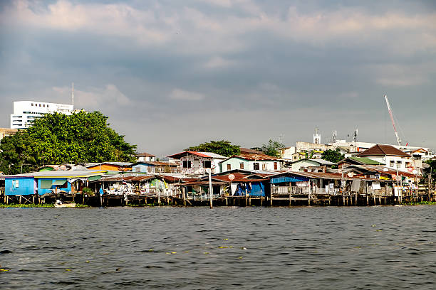 Wooden slums on stilts on the riverside of Chao Praya River in Bangkok, Thailand