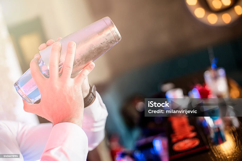 Bartender preparing cocktail in the shaker Cocktails. Shallow DOF. Developed from RAW; retouched with special care and attention; Small amount of grain added for best final impression. 16 bit Adobe RGB color profile. Bartender Stock Photo