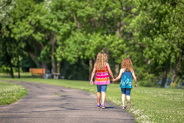 istock Two Young Girls Walking On Trail Holding Hands 540602436
