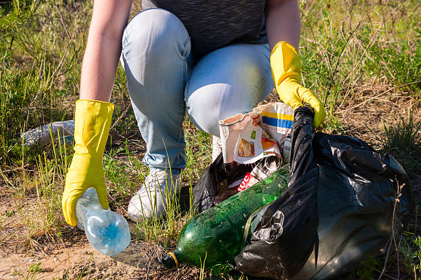 voluntarios chica en amarillo guantes recopila enfoque selectivo de la basura - recycling recycling symbol environmentalist people fotografías e imágenes de stock