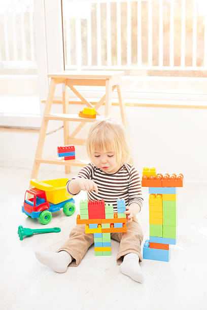 istock Little blond boy playing with colorful plastic blocks 540605966