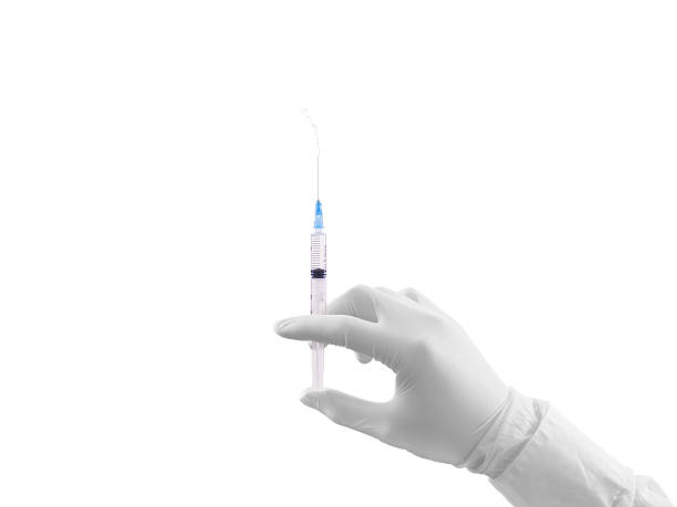 Doctor hand in white glove hold syringe with preparation jet Doctor hand in white glove hold syringe with preparation jet from the needle. Medical man holding injector with drugs in arm. Surgeon hand with vaccine. Syringe with flu vaccine. Medical needle. jet injector stock pictures, royalty-free photos & images