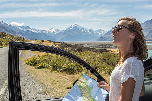 istock Female standing out of car looking at map, Mount Cook 540610442