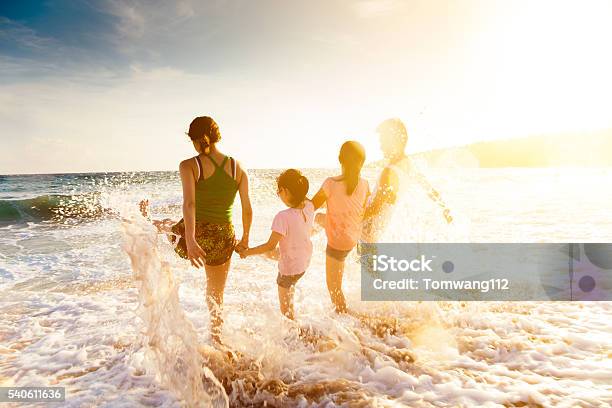 Happy Young Family Playing On Beach At Sunset Stock Photo - Download Image Now - Family, Beach, Summer