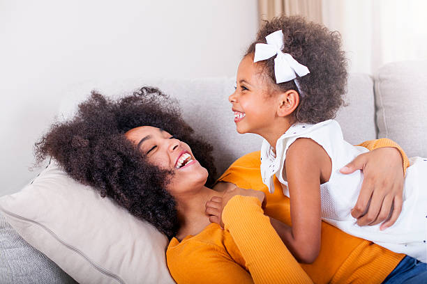 divertida afro-americana mãe e filha tendo diversão em casa. - tickling imagens e fotografias de stock