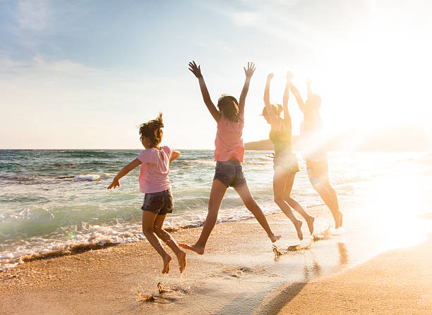 istock happy young family jumping on beach at sunset 540611788