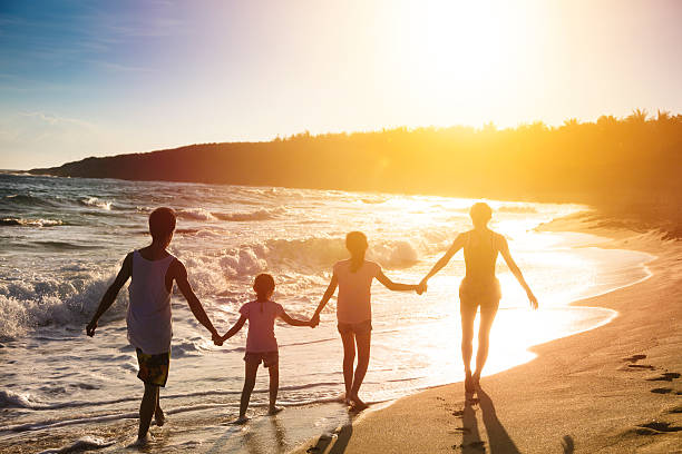 istock happy young family walking on beach at sunset 540611880