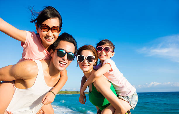 szczęśliwa rodzina zabawy na plaży - fun mother sunglasses family zdjęcia i obrazy z banku zdjęć