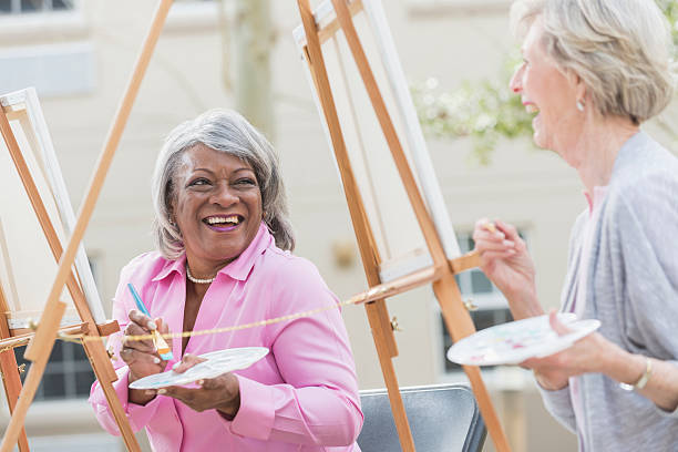 istock Two senior women having fun painting in art class 540716986