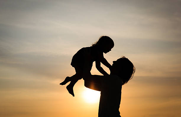 istock Father and little daughter silhouettes at sunset 540717334