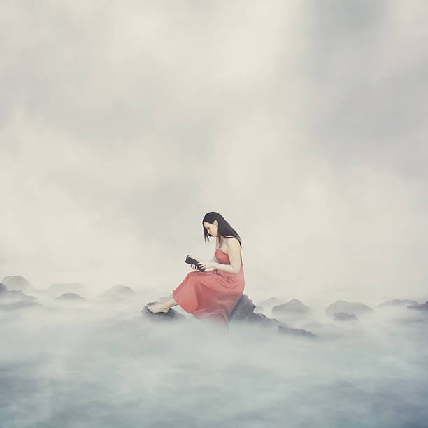 Woman alone on top of the clouds reading her Bible.