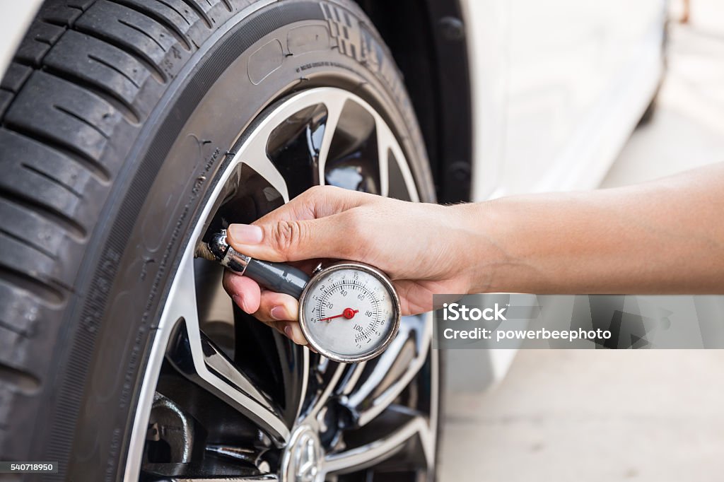 Close-Up Of Hand holding pressure gauge for car tyre Close-Up Of Hand holding pressure gauge for car tyre pressure measurement Tire - Vehicle Part Stock Photo