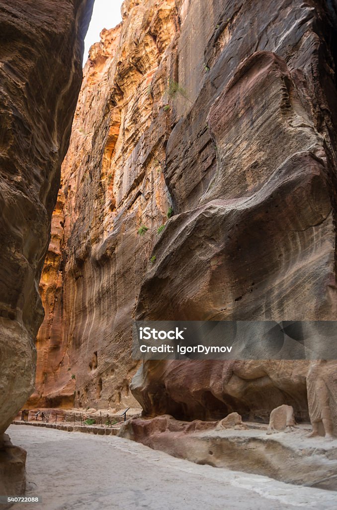 The Siq, the narrow slot-canyon The Siq, the narrow slot-canyon that serves as the entrance passage to the hidden city of Petra, Jordan, Ancient Civilization Stock Photo