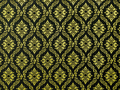 Thai  traditional gold and black floral motif textile background.