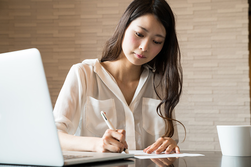 Woman filling out important paper documents
