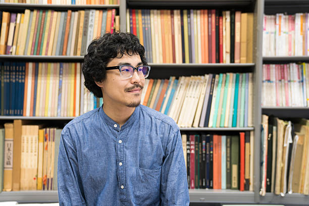 istock Man in front of bookshelf in library 540729412