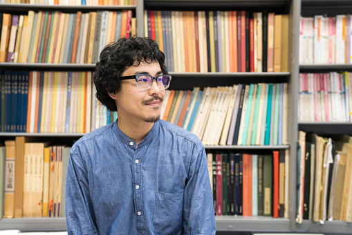 Man in front of bookshelf in library