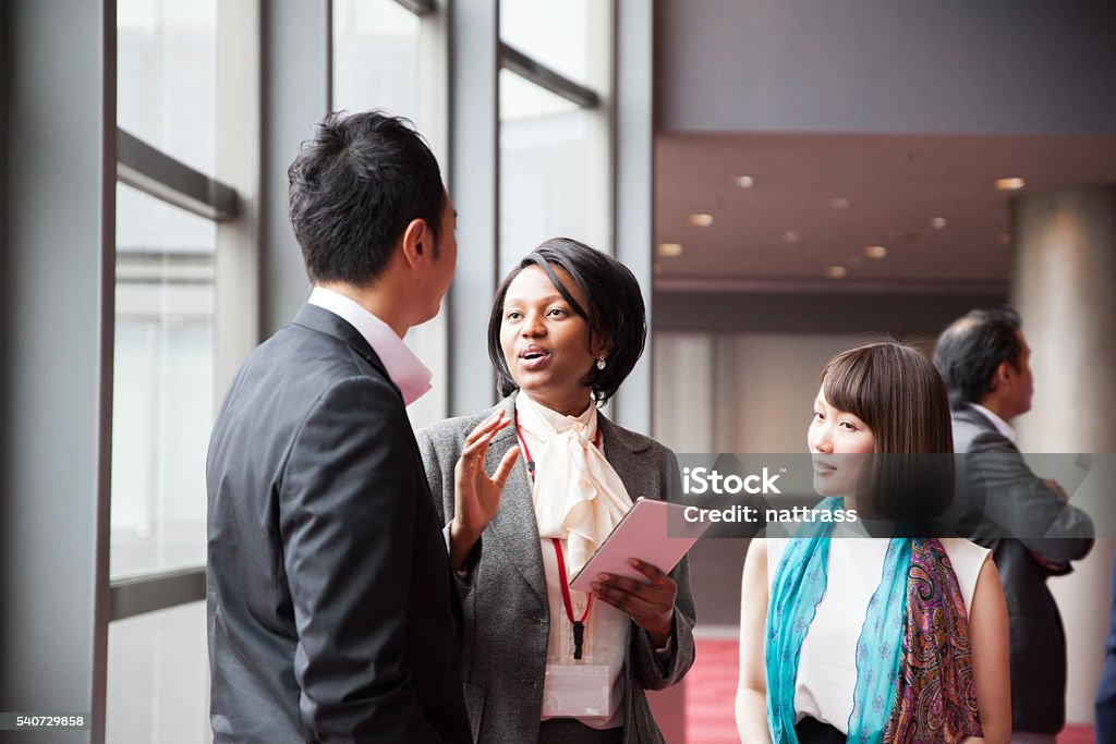 African Female business manager leads the discussion A beautiful african female business manager leads the discussion amongst a small group of people after a conference Business Conference Stock Photo