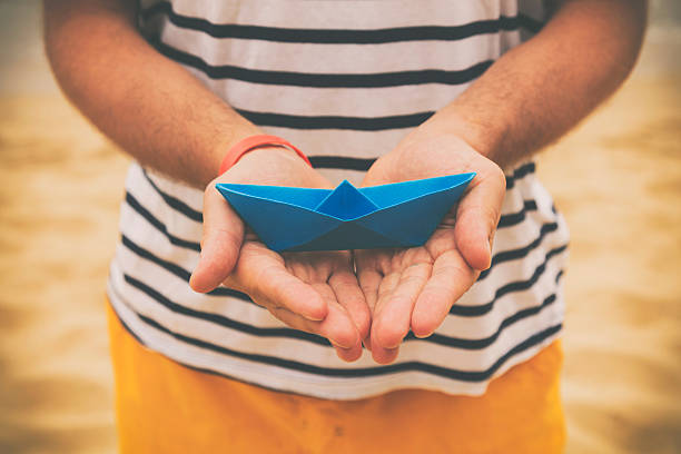 istock Guy holding paper boat outdoors. 540730154