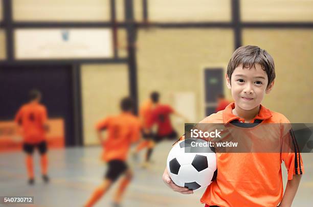 Niño Pequeño Sosteniendo Fútbol En El Gimnasio De Fútbol Sala Foto de stock y más banco de imágenes de Niño