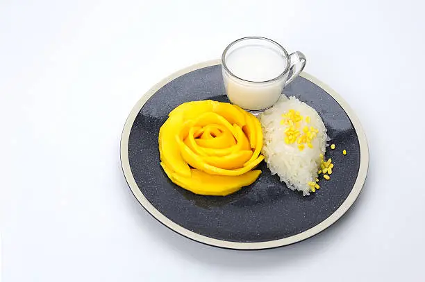 Photo of mango sticky rice with coconut milk place on plate