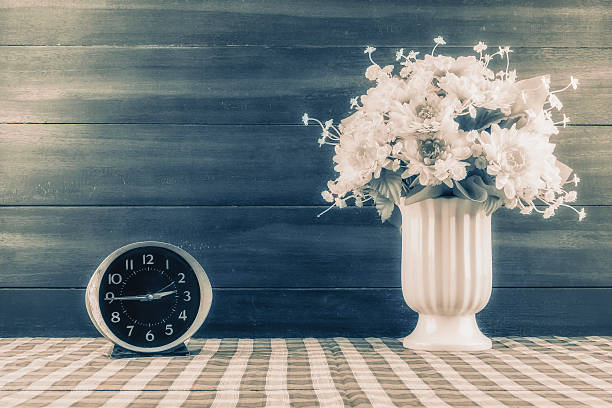 Desk clocks and vases of flowers. Desk clocks and vases of flowers./ Customize them the picture retro./ Create noise and scratches./ Make the image look retro. funeral planning stock pictures, royalty-free photos & images