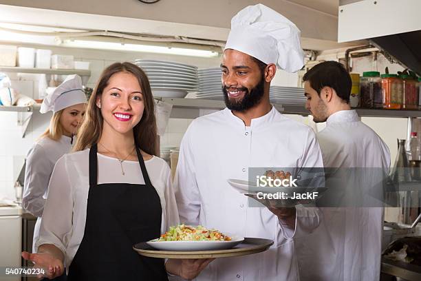 Waitress And Cooking Team At Kitchen Stock Photo - Download Image Now - Assistance, Chef, Retail Clerk