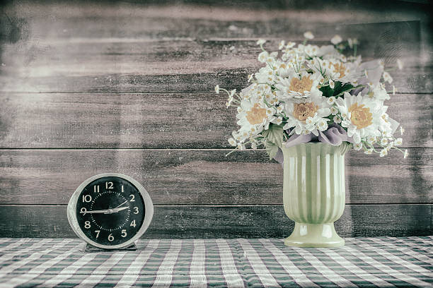 Desk clocks and vases of flowers. Desk clocks and vases of flowers./ Customize them the picture retro./ Create noise and scratches./ Make the image look retro. funeral planning stock pictures, royalty-free photos & images