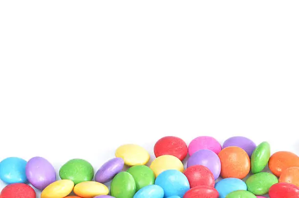 Isolated heap of colored smarties on white background shape like lower frame