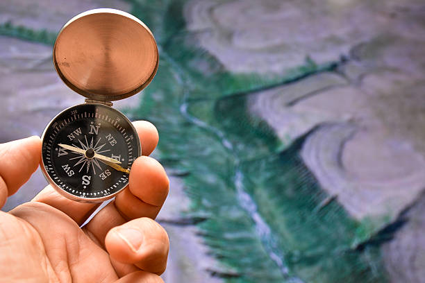 istock Compass in hand on background of the relief. 540742626