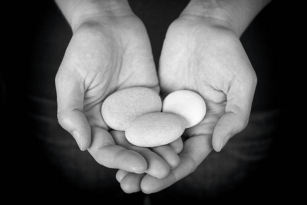 istock Woman holding three stones in her hands 540743576