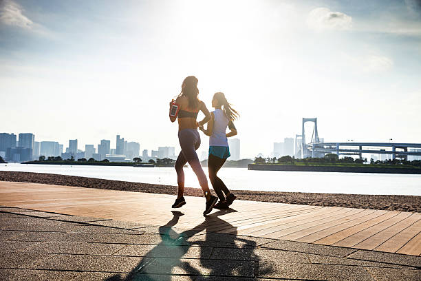 femme jogging dans la ville de tokyo - floatation device flash photos et images de collection