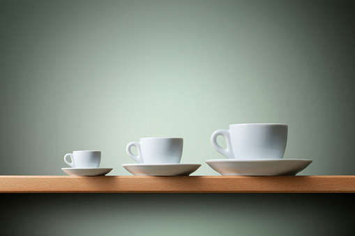 Three coffee cups on the shelf.