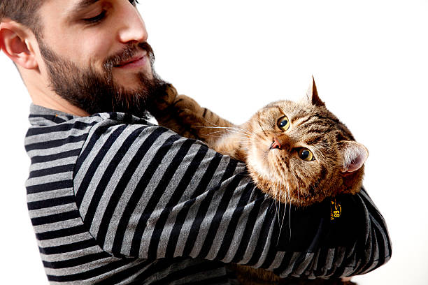 istock bearded young man embracing his beautiful cat on white background 540755366