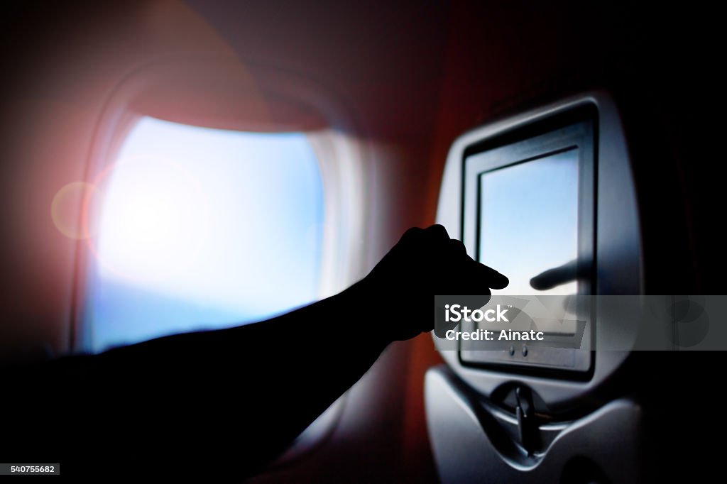 Modern monitor passenger seat on the plane. Airplane window. Seat passenger on the plane screen monitor. Window air travel. Airplane Stock Photo