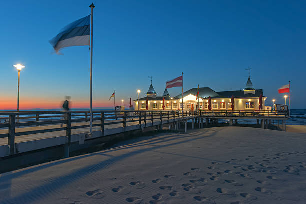 istock Illuminated pier on sand coast at dusk 540759582