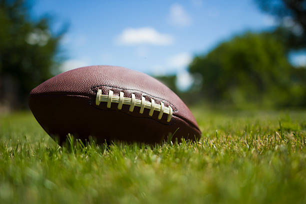 istock american football ball on grass 540761142