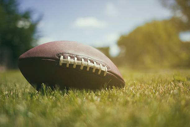 istock American football ball on grass background 540761630